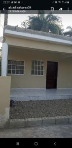 a house with a brown door and a driveway at July in San Felipe de Puerto Plata