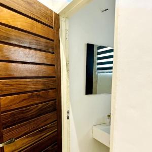 uma porta de madeira numa casa de banho com um espelho em Spacious One Bedroom Apartment em Acra