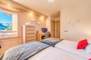 Duas camas num quarto com uma secretária e uma janela em Résidence Les Balcons EtoilÉs - 3 Pièces pour 6 Personnes 301 em Champagny-en-Vanoise