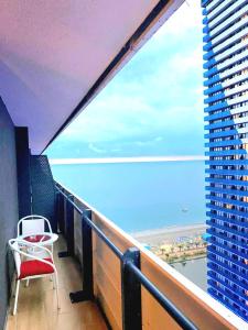 a balcony with a chair and a view of the ocean at ORBI CITY batumi in Batumi