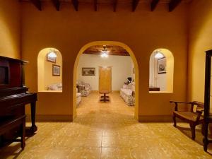 a hallway with a piano in a room with yellow walls at Suite Colonial en Parras de la Fuente in Parras de la Fuente