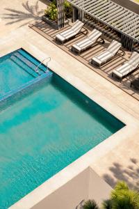 an overhead view of a swimming pool with chaise lounge chairs and a swimming pool at Brittany Hotel Villar City in Cavite
