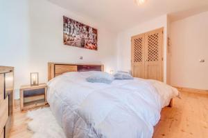 um quarto com uma grande cama branca num quarto em Résidence Les Balcons EtoilÉs - 2 Pièces pour 4 Personnes 431 em Champagny-en-Vanoise