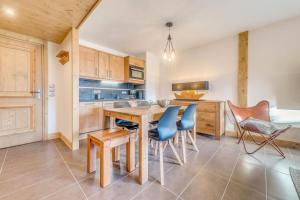 uma cozinha com uma mesa de madeira e cadeiras em Résidence Les Balcons EtoilÉs - 2 Pièces pour 4 Personnes 431 em Champagny-en-Vanoise