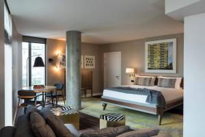 a bedroom with a bed and a living room at Bankside Hotel, Autograph Collection in London