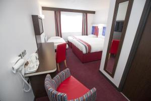 a hotel room with two beds and a mirror at Ramada Milton Keynes in Milton Keynes +35 photos