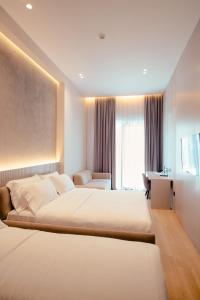 um quarto de hotel com duas camas e uma secretária em La Onda Hotel Durres em Durrës