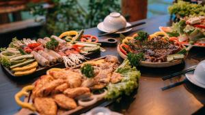 een tafel met veel verschillende soorten voedsel erop bij Kim Ngan Hills Resort Da Lat. in Da Thien