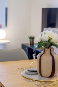 a vase with white flowers sitting on a table at Urban Retreat at 8 Wilmer: Upper Level Studio Gem in Christchurch