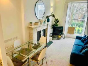 a living room with a glass table and a fireplace at Harrington Apartments in Central London in London