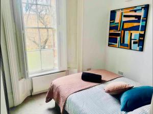 a bedroom with a bed and a painting on the wall at Harrington Apartments in Central London in London