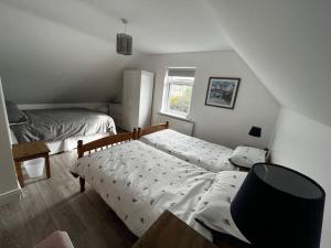 ein Schlafzimmer mit einem Bett, einem Stuhl und einem Fenster in der Unterkunft An Teach Bán in Falcarragh