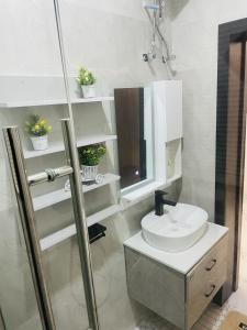 ein weißes Badezimmer mit einem Waschbecken und einem Spiegel in der Unterkunft WHITEFIELD LUXURY APARTMENT in Orimedu