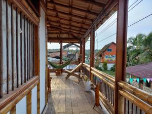 a porch of a house with a hammock on it at Posada mama nati, arusí in Nuquí
