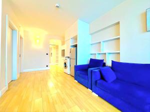 a living room with a blue couch and wooden floors at ORBI SITY BATUMI in Batumi