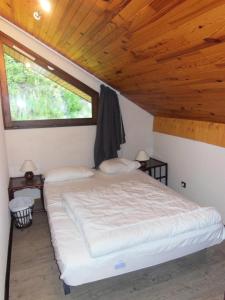 Ce lit se trouve dans un dortoir doté d'un plafond en bois. dans l'établissement Résidence Dryades - Les Hauts De Planchamp - 3 Pièces pour 6 Personnes 651, à Champagny-en-Vanoise