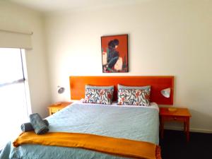 a bedroom with a large bed with a wooden headboard at 24 Gillies St Apartment in Warrnambool +7 photos