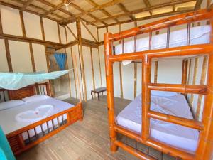 a room with two bunk beds and a table at Posada mama nati, arusí in Nuquí