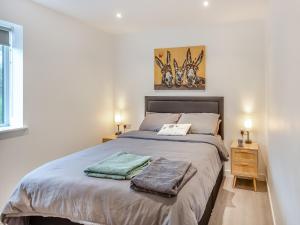 una camera da letto con un letto e due asciugamani di Hedd Wen a Llanllyfni