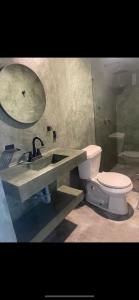 a bathroom with a toilet and a sink and a mirror at Habitación con baño privado exterior in Mexico City