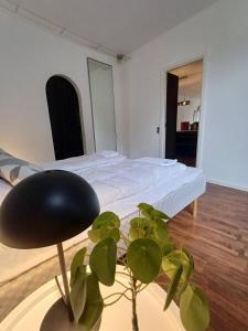- une chambre avec un lit et une plante en pot dans l'établissement Stylish Apartment On Pedestrian Street Randers, à Randers