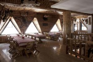 a dining room with tables and chairs in a building at Pensiunea Rosenau in Râşnov