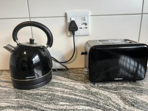 a black tea kettle and toaster on a counter at Sea Point at Princeton Place in Cape Town