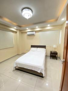 1 dormitorio con cama y pizarra en la pared en beautiful penthouse Santo Domingo, en Santo Domingo