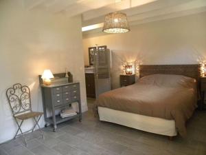 Aumeville-LestreにあるHoliday home La Jardinerieのベッドルーム1室(ベッド1台、テーブル、椅子付)
