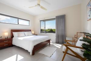 1 dormitorio con cama y ventana grande en Sea&Country Kiama - Stunning Views-Relaxing-Spacious-Deck-EVC en Kiama