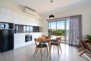 a kitchen and dining room with a table and chairs at Sea&Country Kiama - Stunning Views-Relaxing-Spacious-Deck-EVC in Kiama
