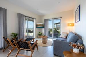 基亞馬的住宿－Sea&Country Kiama - Stunning Views-Relaxing-Spacious-Deck-EVC，客厅配有蓝色的沙发和椅子