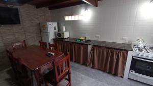 a kitchen with a counter and a table and a refrigerator at Del muelle in Miramar