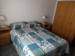 una camera con un letto con una trapunta sopra di Del muelle a Miramar