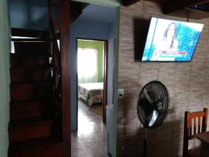 Habitación con TV de pantalla plana y ventilador. en Del muelle en Miramar