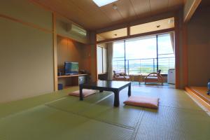 uma sala de estar com uma mesa e uma grande janela em 南郷温泉　二葉屋 em Otsu