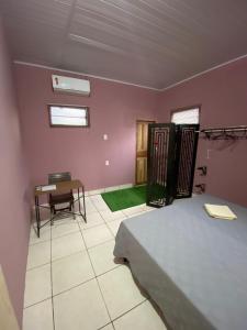Schlafzimmer mit einem Bett, einem Schreibtisch und einem Tisch in der Unterkunft POUSADA DO PORTAL in Rio Branco