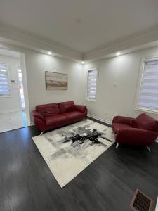 a living room with a red couch and a rug at Your home away from home in Hamilton