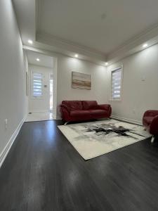 a living room with a red couch and a rug at Your home away from home in Hamilton