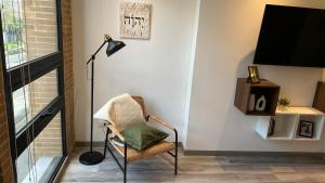 ボゴタにあるApartasuite Central y Moderno Teusaquillo Centro Internacionalのリビングルーム(椅子、ランプ付)