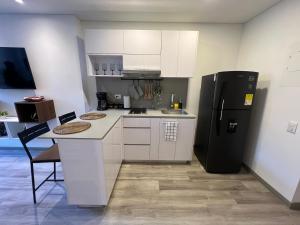 ボゴタにあるApartasuite Central y Moderno Teusaquillo Centro Internacionalの白いキャビネットと黒い冷蔵庫のあるキッチン +34枚の写真