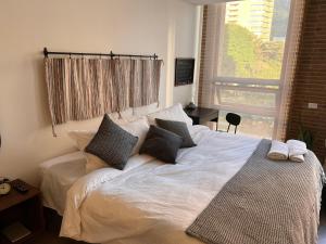 ボゴタにあるApartasuite Central y Moderno Teusaquillo Centro Internacionalのベッドルーム1室(枕付きのベッド1台、窓付)