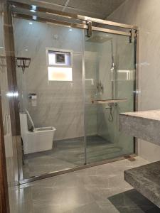 y baño con ducha de cristal y aseo. en STAY IN A LUXURIOUS VILLA AT AJMAN UAE BY MAUON TOURISM, en Al Ḩamīdīyah