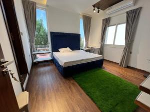 1 dormitorio con cama y alfombra verde en STAY IN A LUXURIOUS VILLA AT AJMAN UAE BY MAUON TOURISM, en Al Ḩamīdīyah