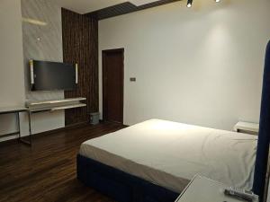 Habitación de hotel con cama y TV de pantalla plana. en STAY IN A LUXURIOUS VILLA AT AJMAN UAE BY MAUON TOURISM, en Al Ḩamīdīyah