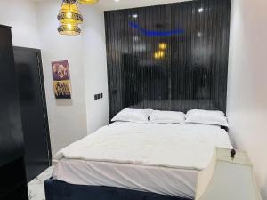 ein großes Bett in einem Zimmer mit Fenster in der Unterkunft WHITEFIELD LUXURY APARTMENT in Orimedu