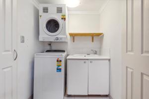a small kitchen with a washing machine and a sink at Central Fremantle 2 Bedroom - Walk to Shops and Beach in Fremantle