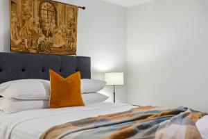 a bedroom with a large bed with an orange pillow at Central Fremantle 2 Bedroom - Walk to Shops and Beach in Fremantle
