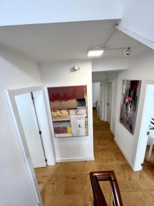 Habitación con paredes blancas y cuadros en las paredes. en Oeiras Beach Guest House, en Oeiras