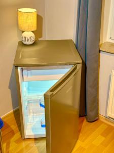 a small brown table with an empty refrigerator at 2 Zimmer, Garten, Terrasse, Bad mit Dusche und WC und Gemeinschaftsküche in Ilsede